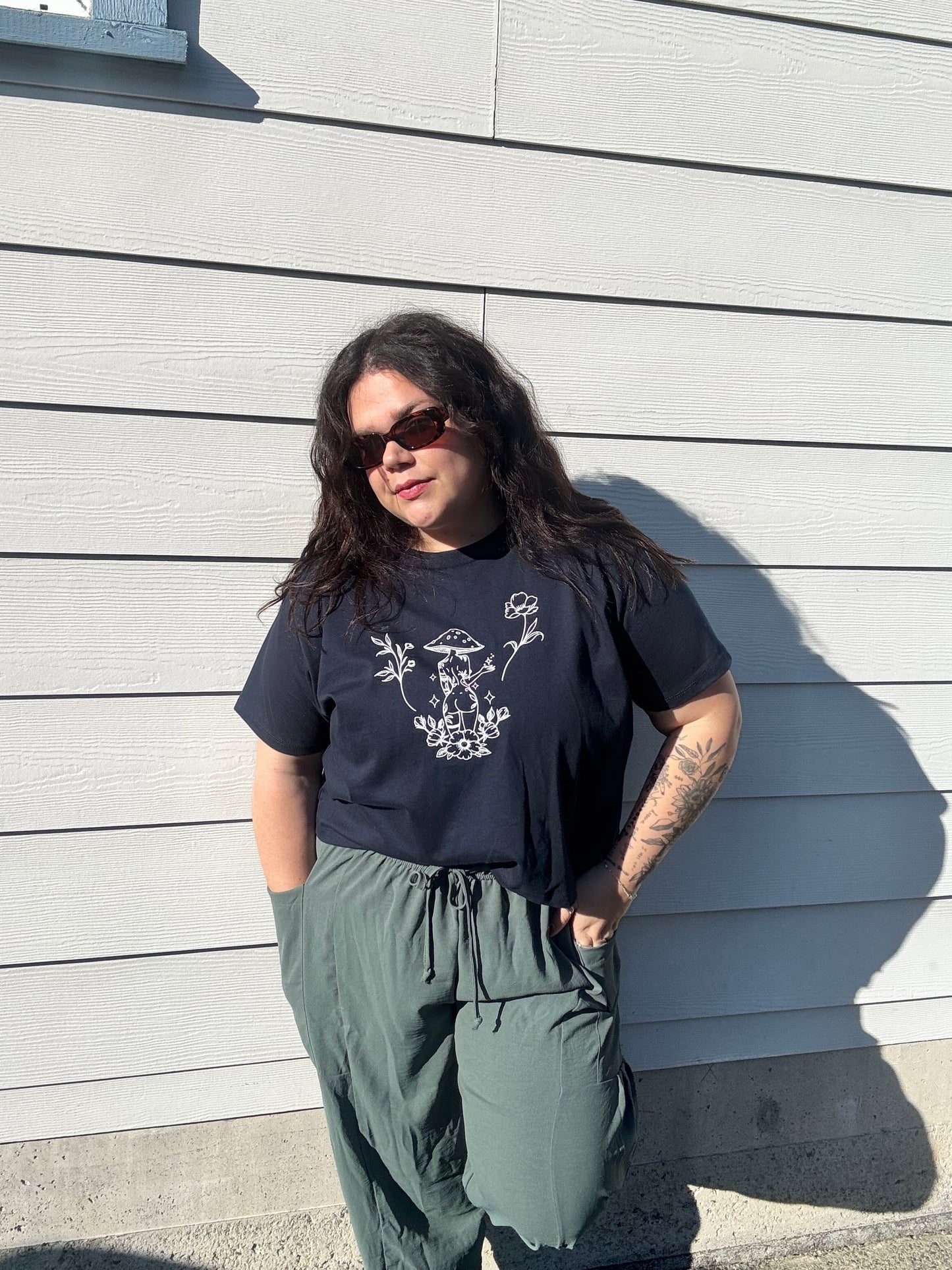 Person wearing a black t-shirt with white graphics on a wooden deck