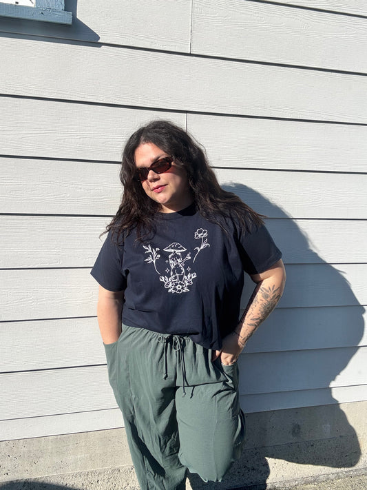 Person wearing a black t-shirt with white graphics on a wooden deck